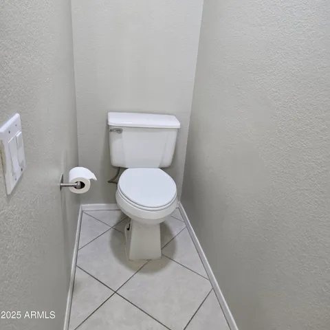 a white toilet sitting next to a white wall