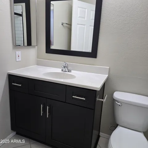 a bathroom with a sink vanity and a toilet