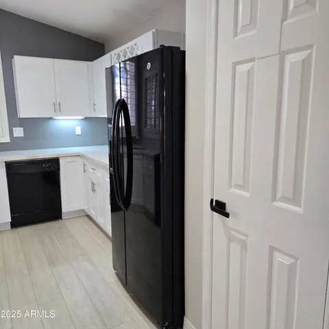 a kitchen with a refrigerator and cabinets