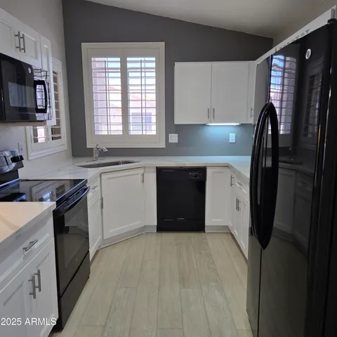 a kitchen with stainless steel appliances a refrigerator sink and microwave