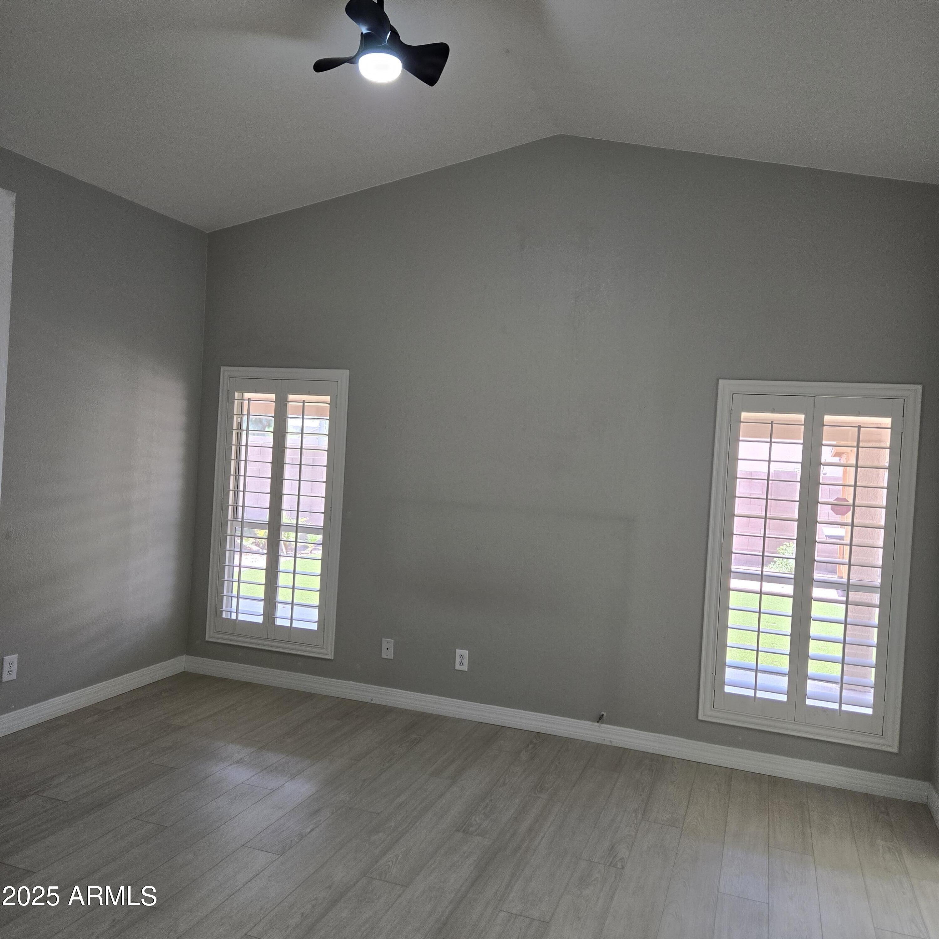 11525 West Cottontail Court Surprise, AZ 85378 - Photo 10 of 21 an empty room with wooden floor cabinet and windows