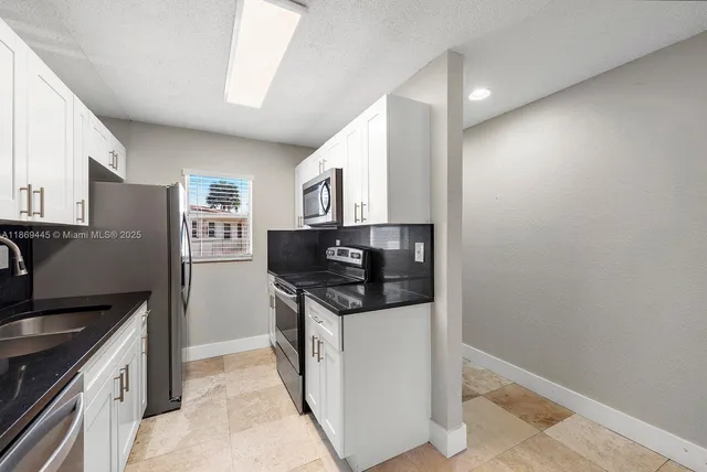 a kitchen with stainless steel appliances granite countertop a stove a refrigerator and a sink