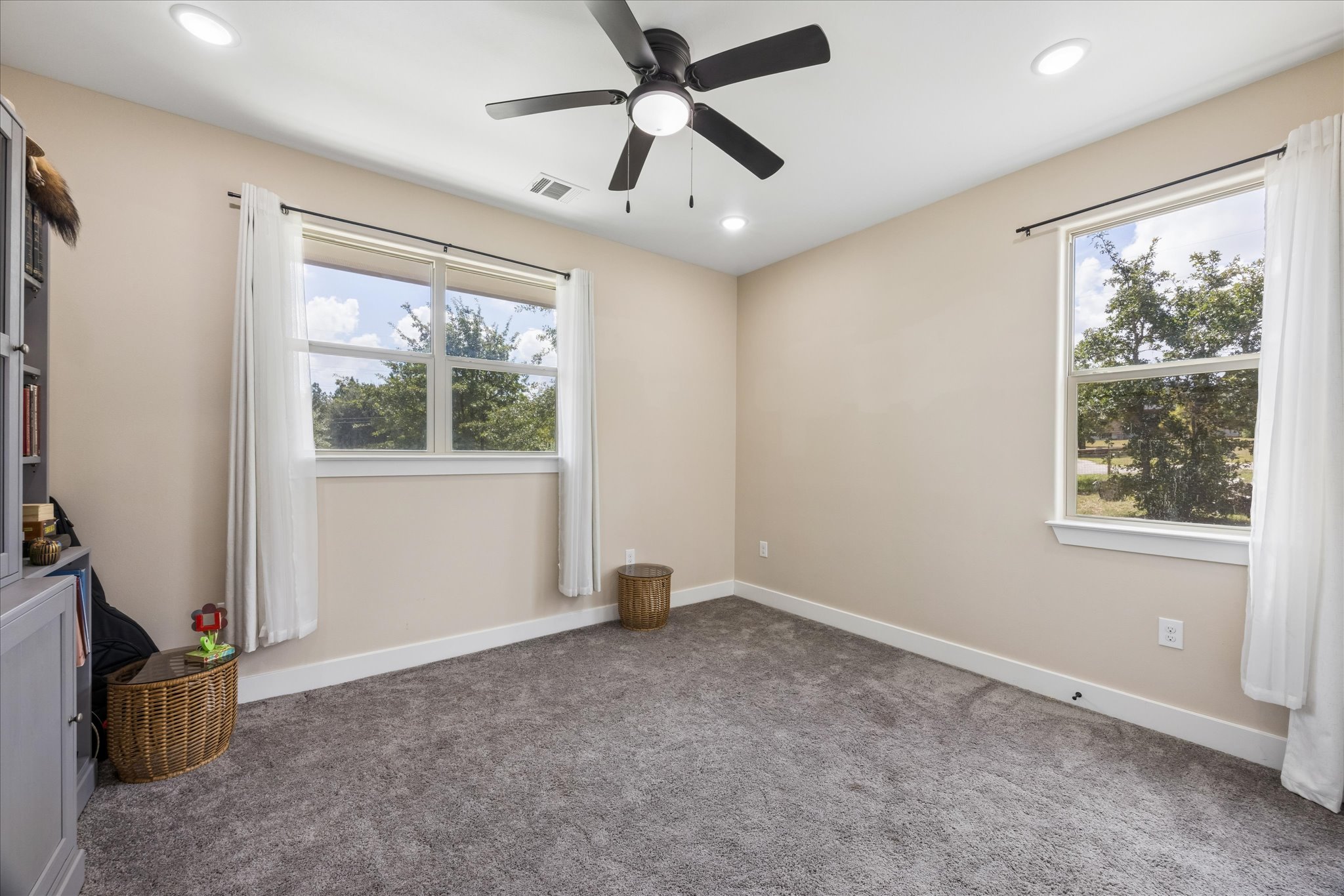 116 Mallard Road Bastrop, TX 78602 - Photo 15 of 31 Plush carpeting and multiple windows create a comfortable and inviting bedroom atmosphere.