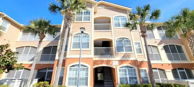 a front view of a multi story residential apartment building with a yard