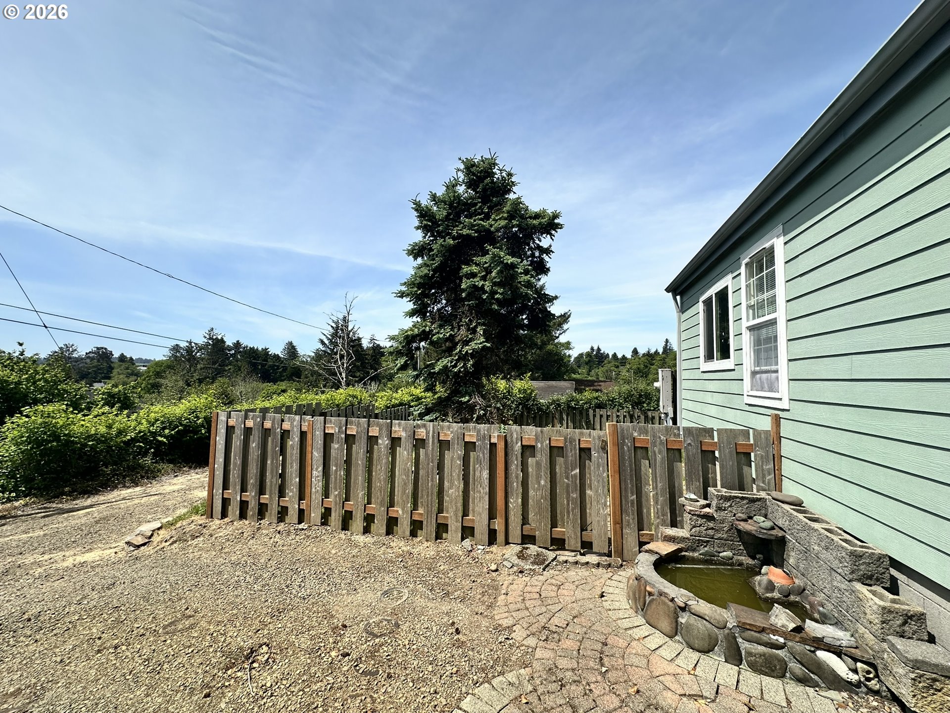 4821 Northeast 50th Street Neotsu, OR 97364 - Photo 3 of 19 a view of a backyard with wooden fence and a couple of flower plants