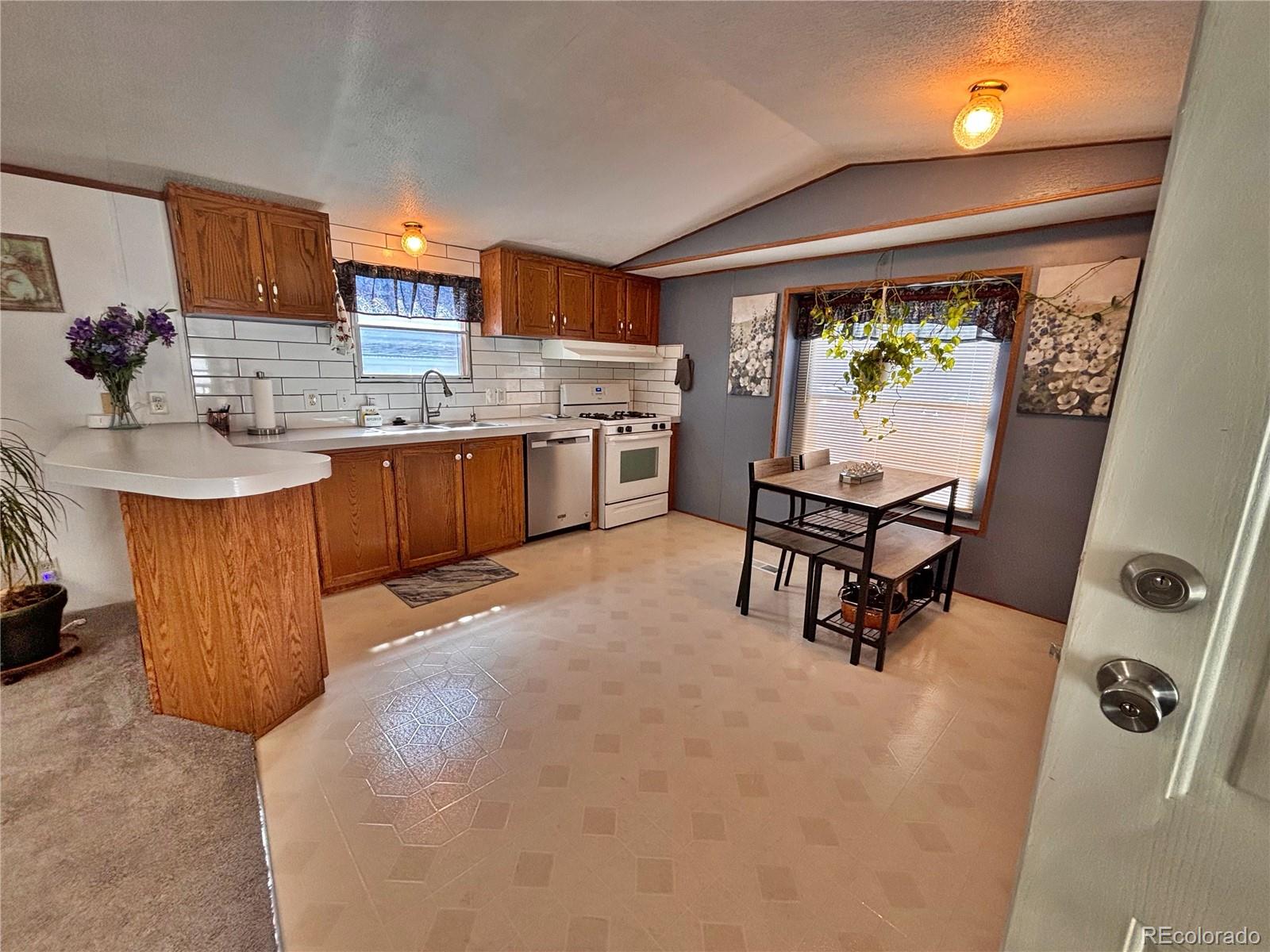 230 North 2nd Street Berthoud, CO 80513 - Photo 12 of 44 a room with stainless steel appliances kitchen island furniture and a large window