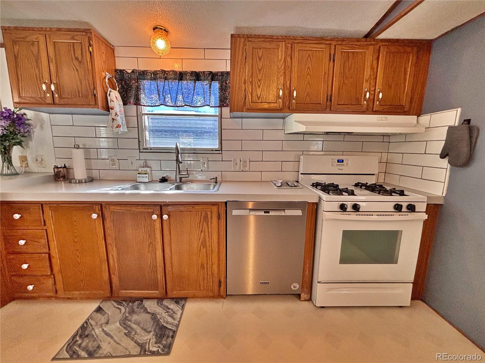 230 North 2nd Street Berthoud, CO 80513 - Photo 15 of 44 a kitchen with a sink stove and cabinets