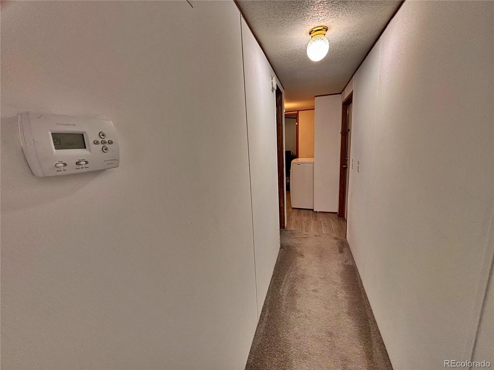 230 North 2nd Street Berthoud, CO 80513 - Photo 23 of 44 a view of a hallway with wooden floor and a bathroom