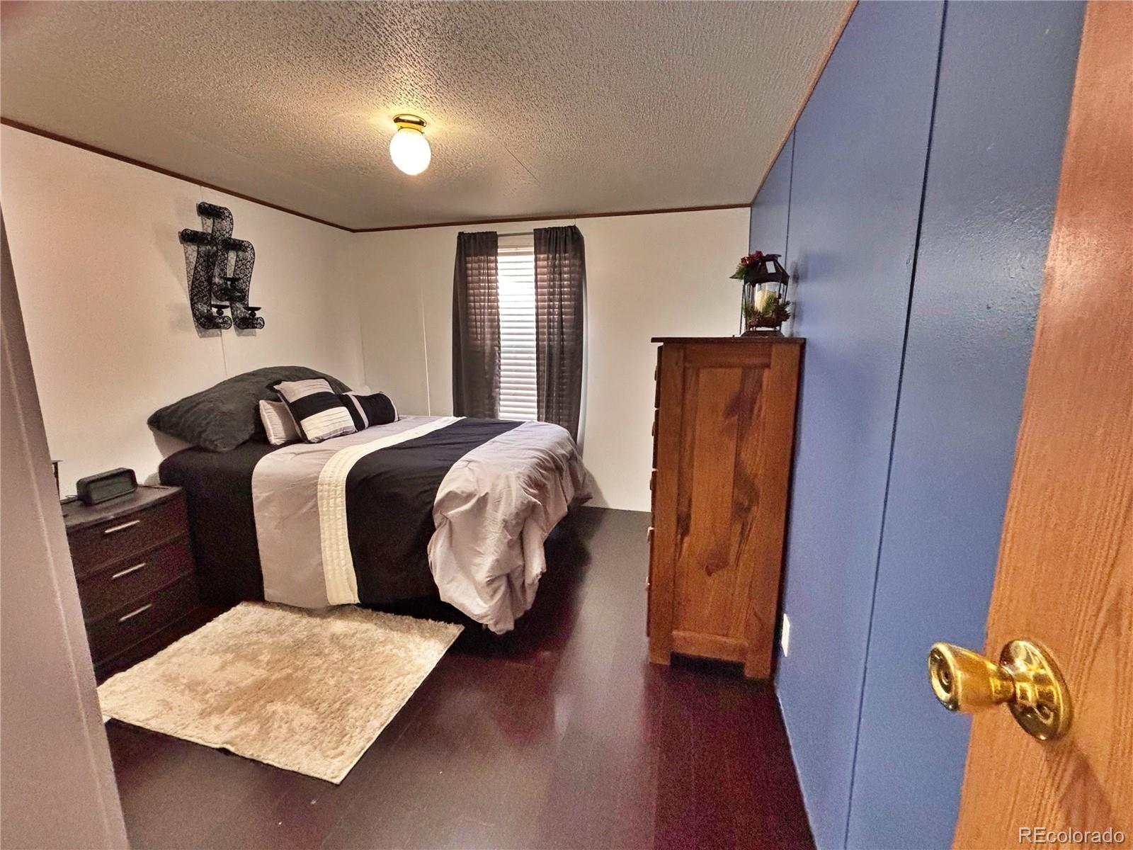 230 North 2nd Street Berthoud, CO 80513 - Photo 25 of 44 a bedroom with bed and wooden floor