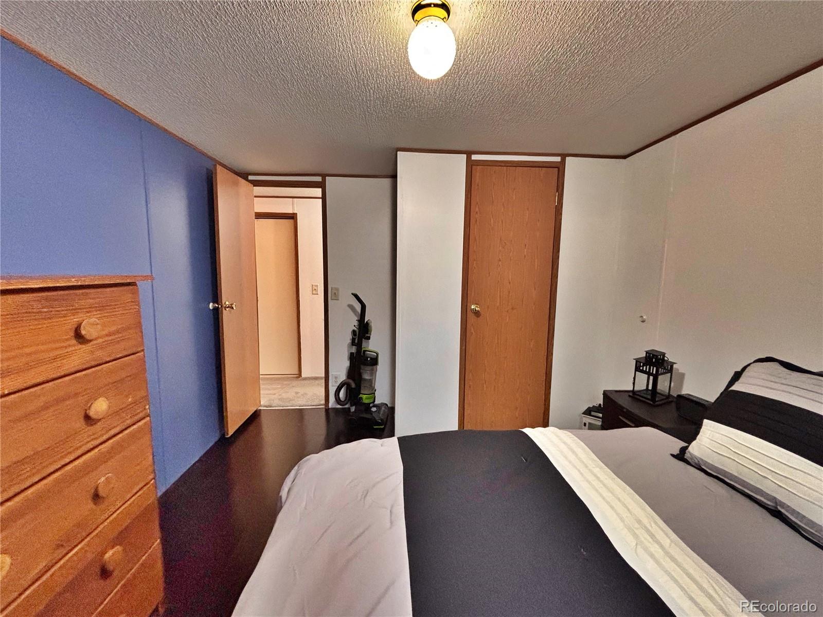 230 North 2nd Street Berthoud, CO 80513 - Photo 26 of 44 a bedroom with a bed and wooden floor