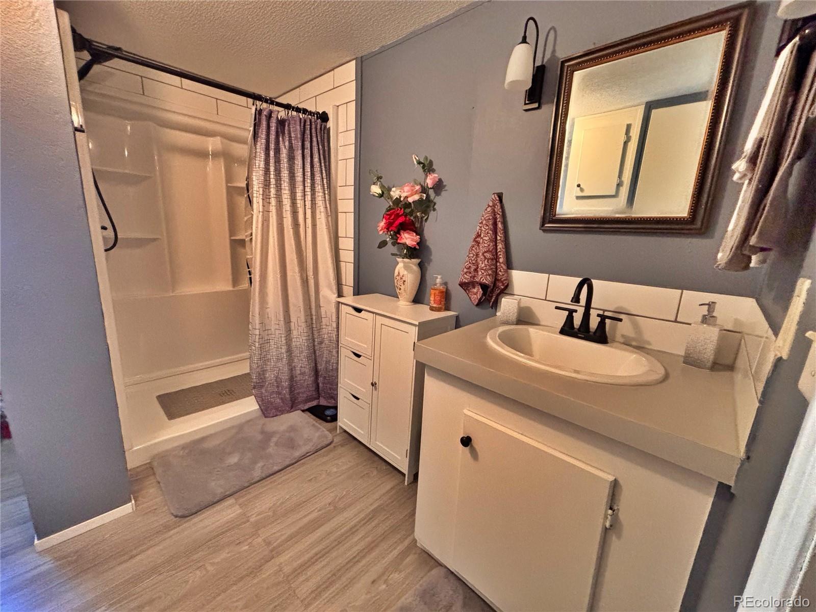230 North 2nd Street Berthoud, CO 80513 - Photo 31 of 44 a bathroom with a double vanity sink mirror and shower