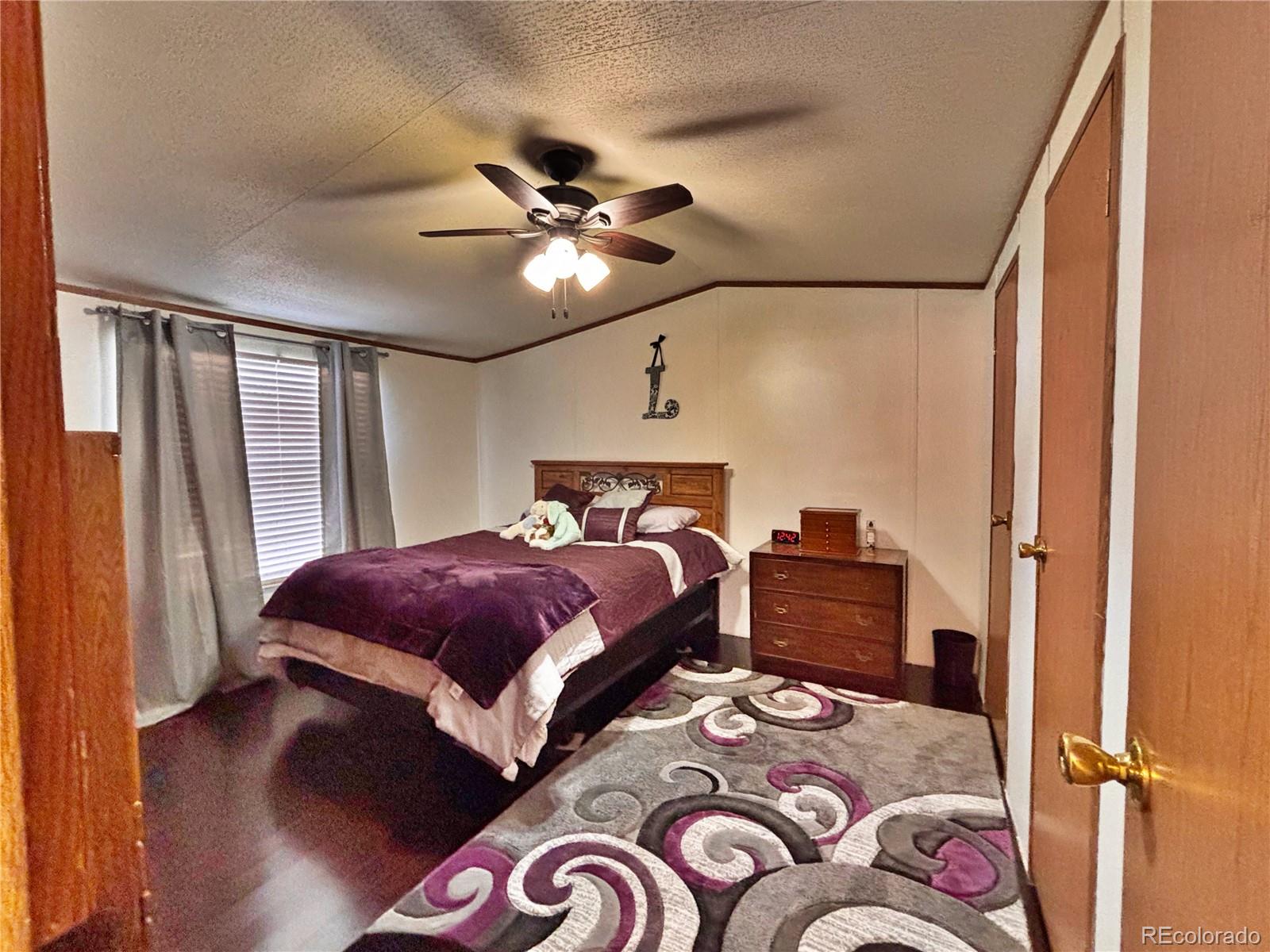 230 North 2nd Street Berthoud, CO 80513 - Photo 35 of 44 a bedroom with a bed and a chandelier