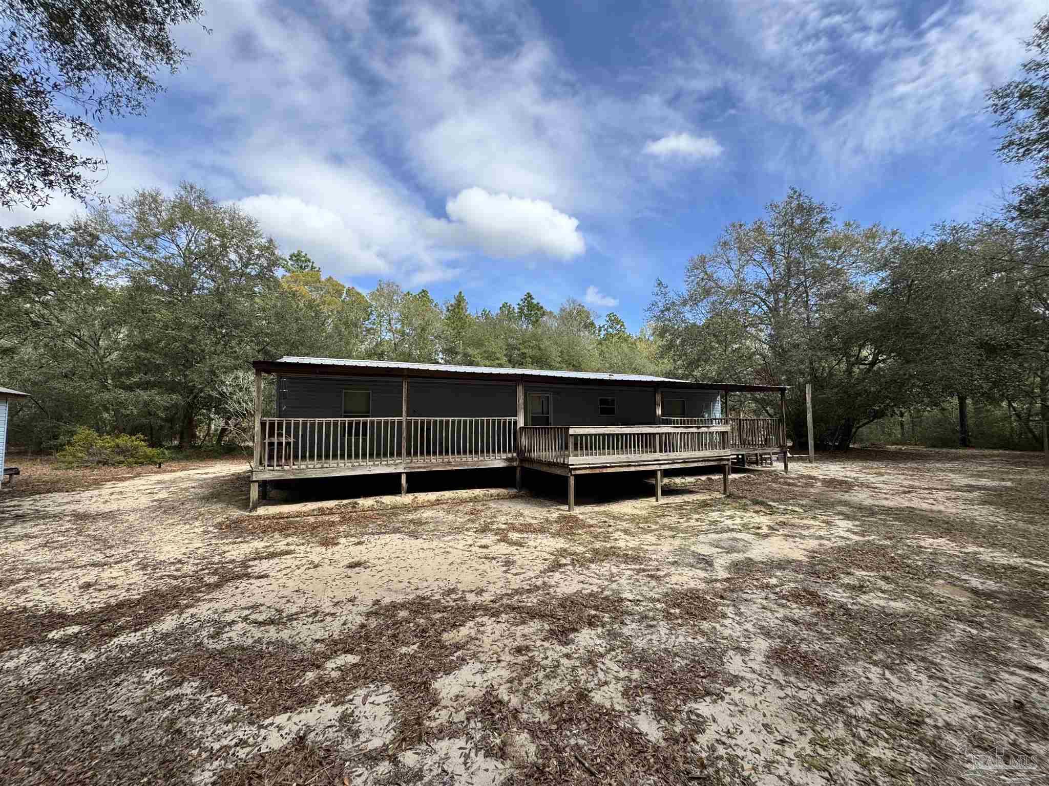 6512 Winston Brown Road Milton, FL 32570 - Photo 2 of 37 a view of backyard with wooden fence and large trees