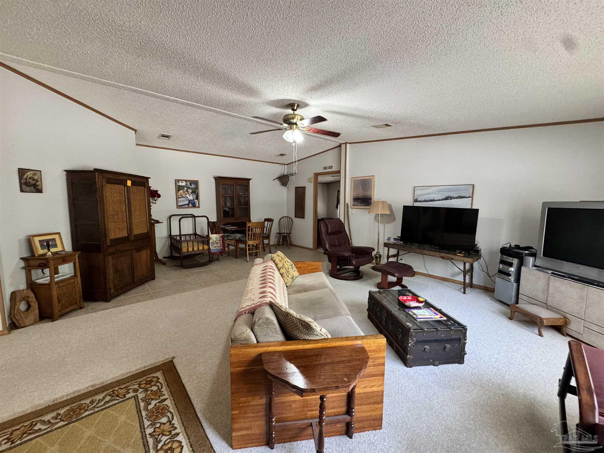 6512 Winston Brown Road Milton, FL 32570 - Photo 3 of 37 a living room with furniture a flat screen tv and a refrigerator