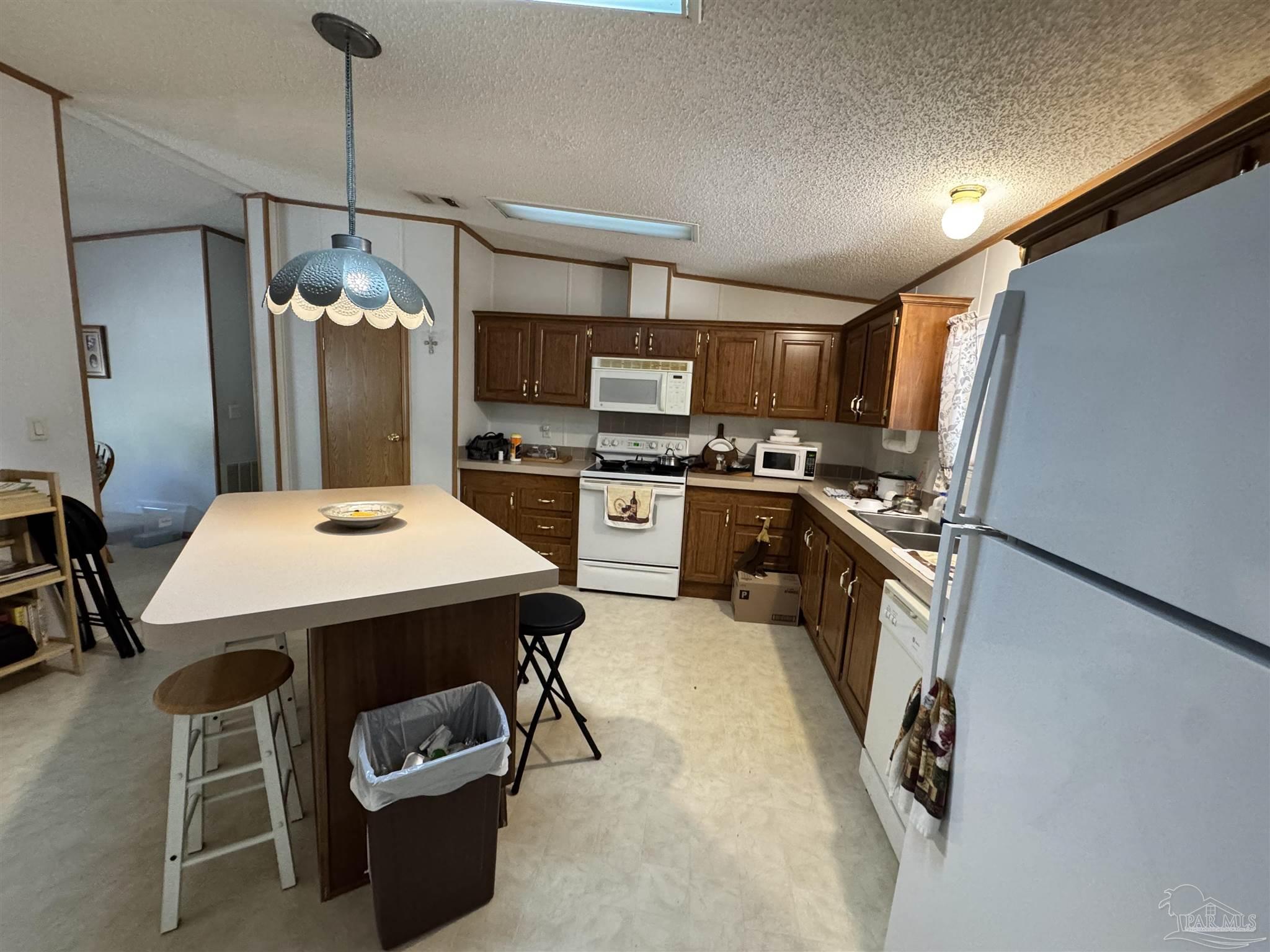 6512 Winston Brown Road Milton, FL 32570 - Photo 5 of 37 a kitchen with sink refrigerator and stove