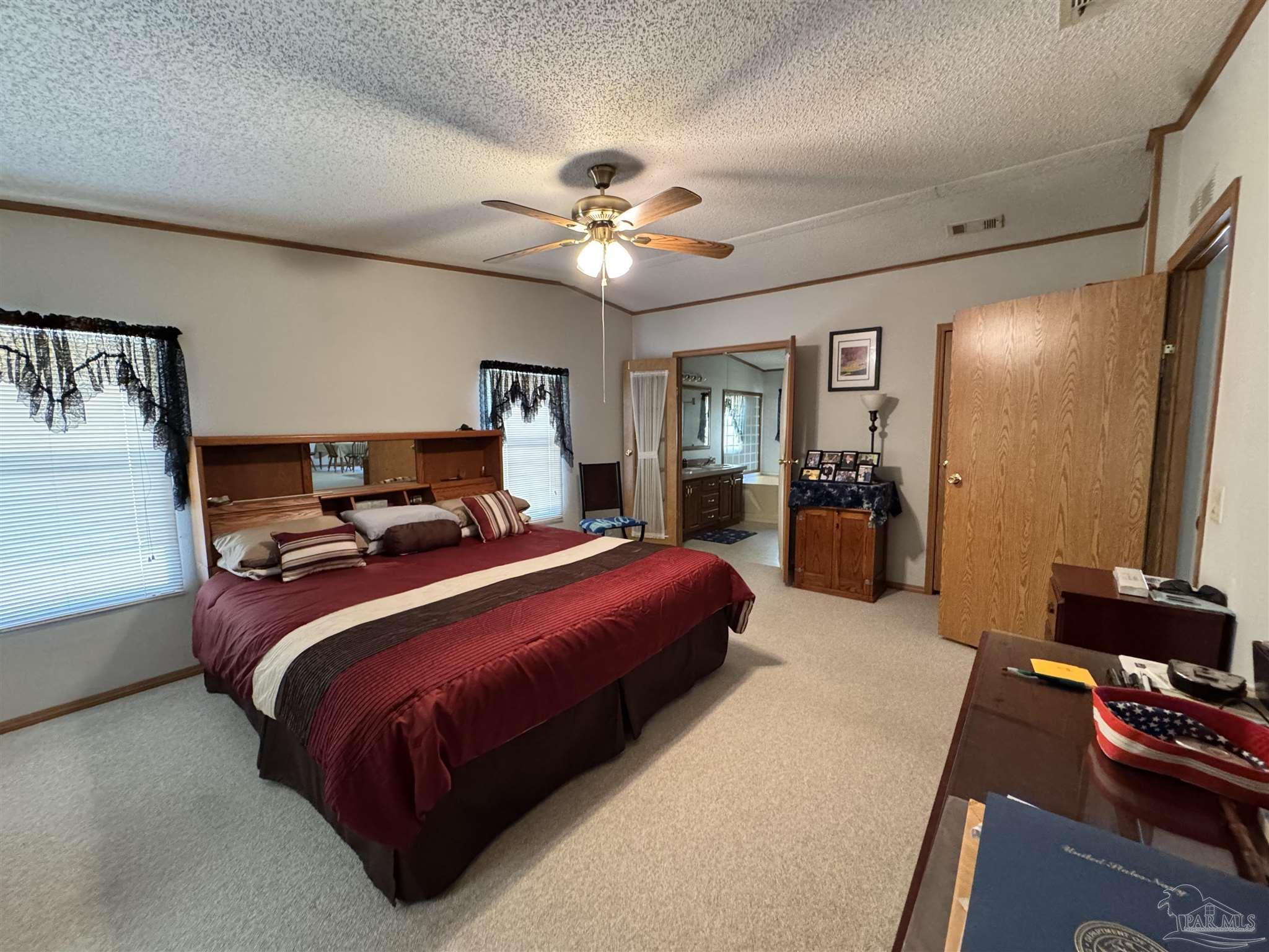 6512 Winston Brown Road Milton, FL 32570 - Photo 10 of 37 a bedroom with a bed and a chandelier