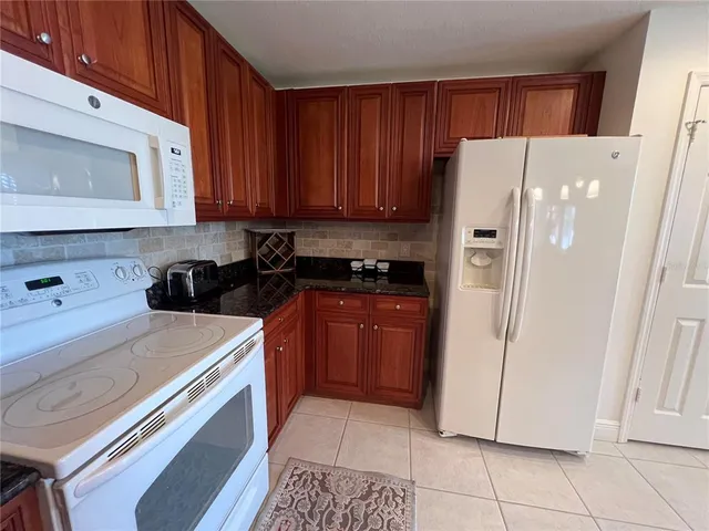 a kitchen with a refrigerator sink and cabinets