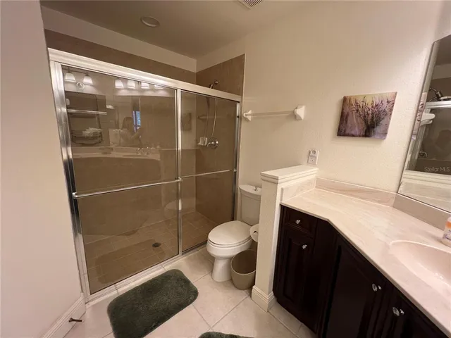 a bathroom with a granite countertop toilet sink and shower