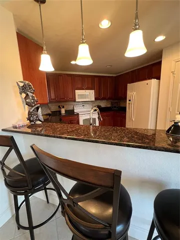a kitchen with a table chairs sink and cabinets