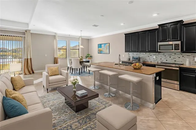 a living room with stainless steel appliances kitchen island granite countertop a couch and a view of living room