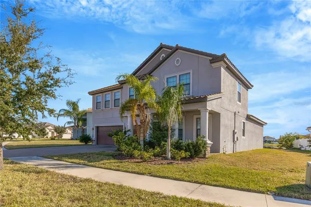 a front view of house with yard and trees in the background