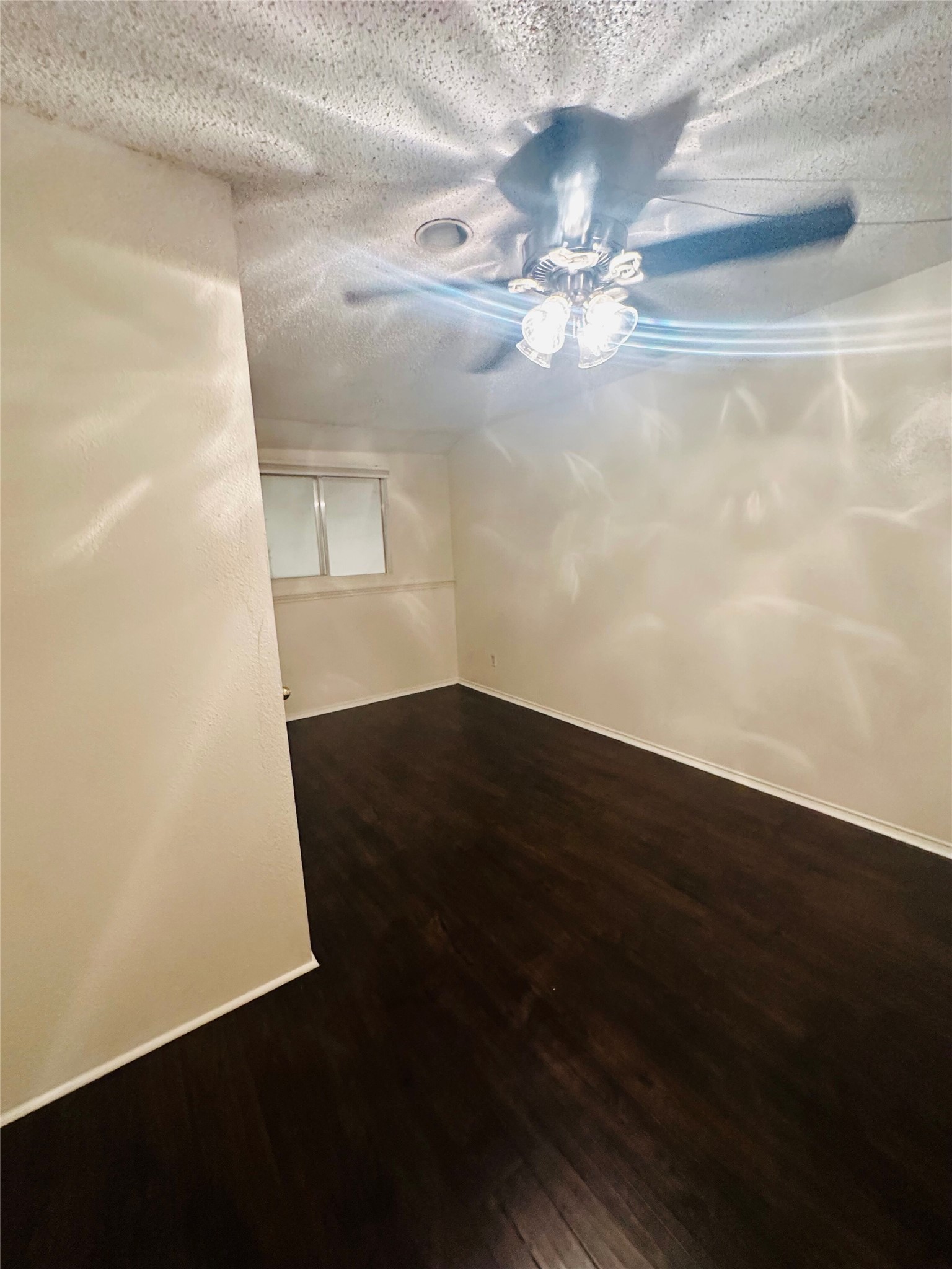 2401 Leon Street, Unit 307 Austin, TX 78705 - Photo 22 of 25 a view of an empty room with wooden floor and fan