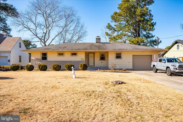 a front view of a house with a yard covered in snow