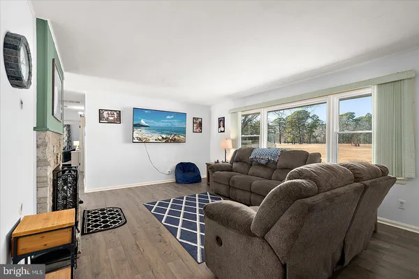 a kitchen with white cabinets and wooden floor
