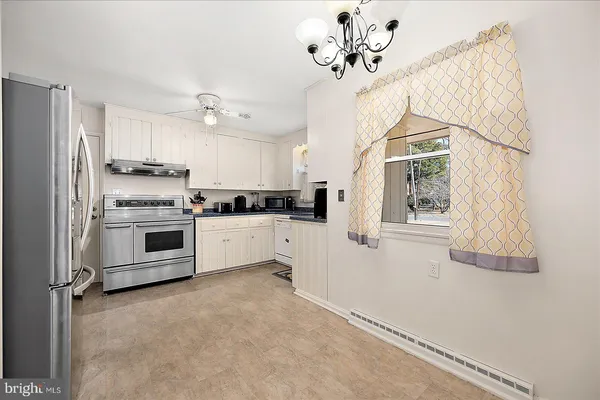 a view of a kitchen with a refrigerator and mirror