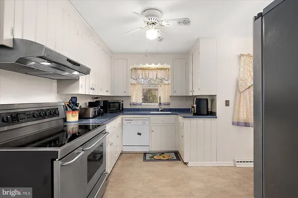 a kitchen with stainless steel appliances granite countertop a refrigerator and a stove