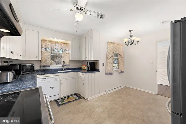 a view of a dining room with furniture large windows and a chandelier