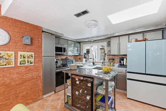 a kitchen with stainless steel appliances granite countertop a refrigerator and a stove top oven