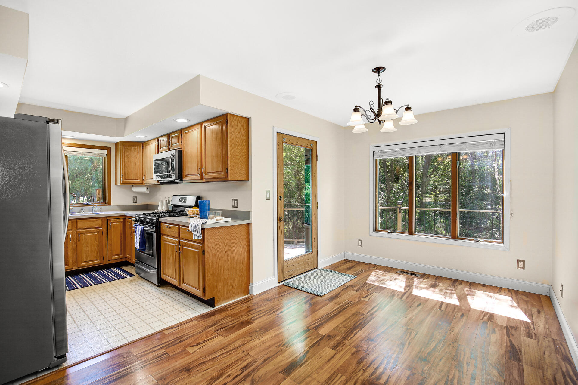 2196 Elm Tree Lane Crown Point, IN 46307 - Photo 16 of 30 a open kitchen with granite countertop a stove top oven a sink dishwasher a dining table and chairs with wooden floor