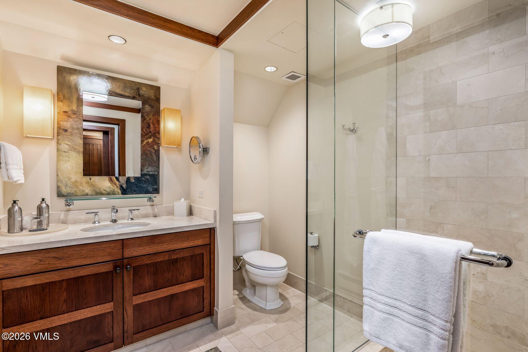 1 Vail Road, Unit 9204 Vail, CO 81657 - Photo 18 of 27 a bathroom with a double vanity sink toilet mirror and shower