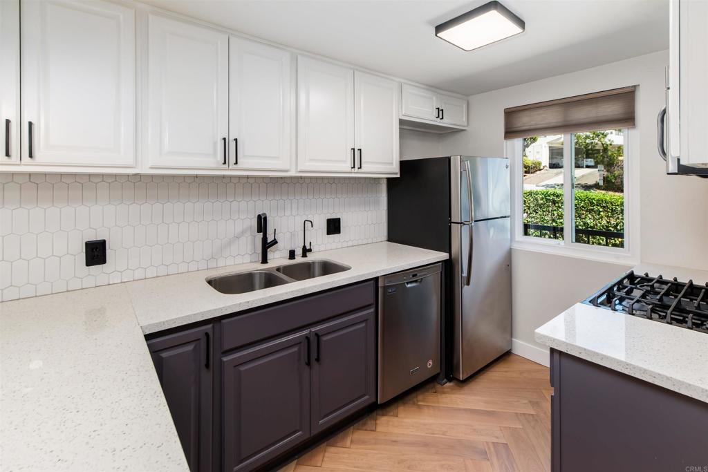 2349 Altisma Way, Unit B Carlsbad, CA 92009 - Photo 5 of 25 a kitchen with stainless steel appliances granite countertop a sink stove and refrigerator