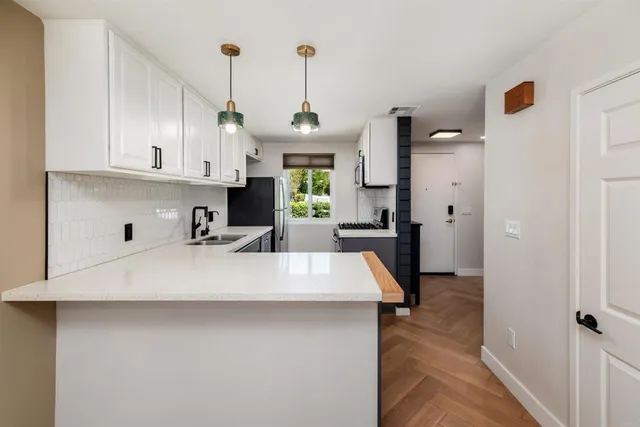 a view of a kitchen with kitchen island a sink wooden floor and window
