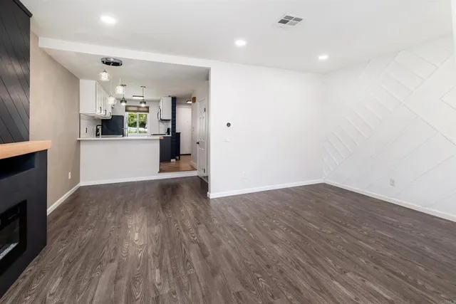 a view of a kitchen with wooden floor and a refrigerator