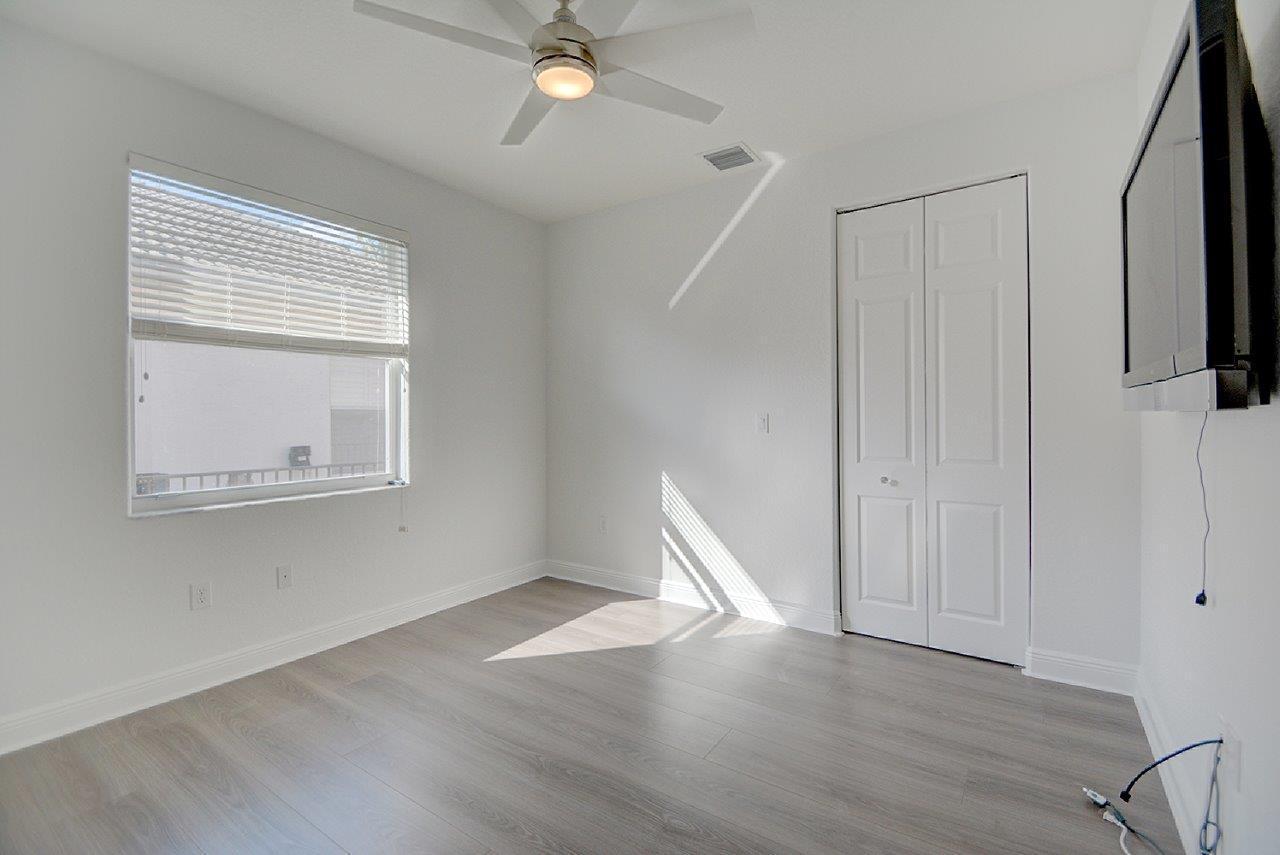 19473 Saturnia Lakes Drive Boca Raton, FL 33498 - Photo 16 of 22 a view of an empty room with wooden floor and a window