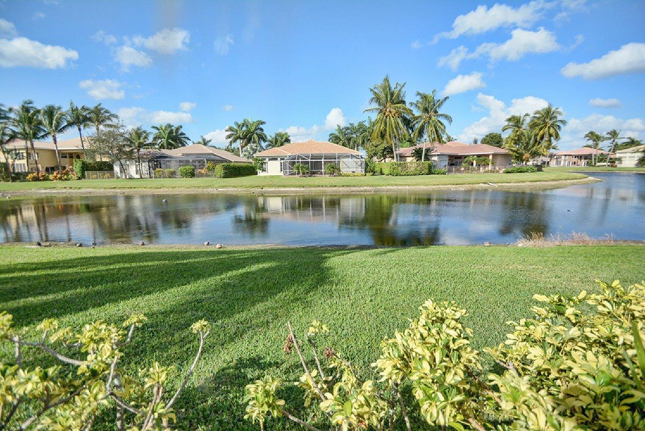 19473 Saturnia Lakes Drive Boca Raton, FL 33498 - Photo 19 of 22 a view of a lake with a house in the background