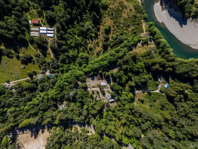 a view of a house with a lush green forest