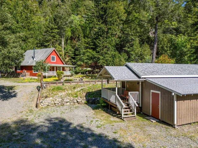 a view of a lake with a yard and large trees