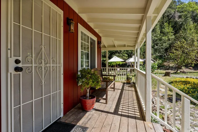 a balcony with potted plants and wooden floor