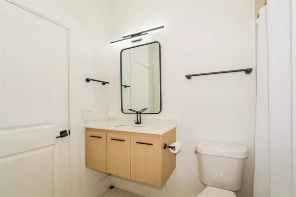 a bathroom with a sink a toilet and mirror