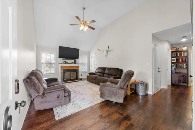 a living room with furniture a fireplace and a flat screen tv