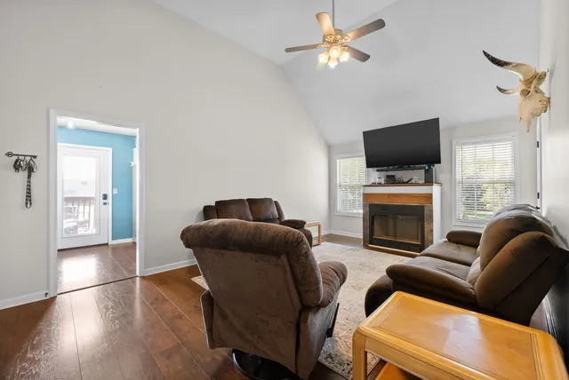 a living room with furniture a flat screen tv and a fireplace