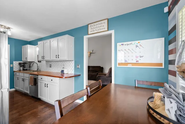a kitchen with stainless steel appliances white cabinets and wooden floor