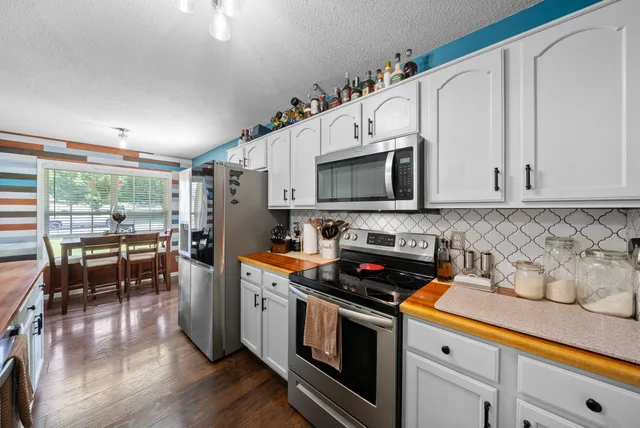 a kitchen with granite countertop a stove a sink and a microwave