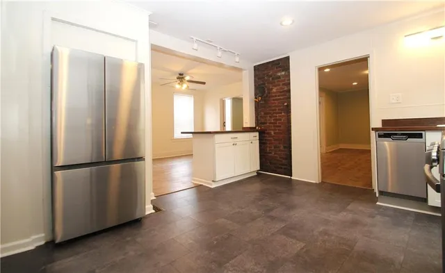 a view of kitchen with refrigerator and wooden floor