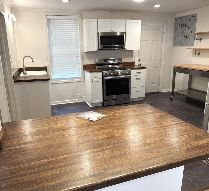 1406 Firth Street, Unit 1 Pittsburgh, PA 15212 - Photo 17 of 19 a kitchen with stainless steel appliances wooden floor sink and stove