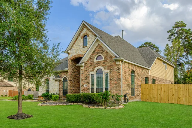 a front view of a house with a yard and trees